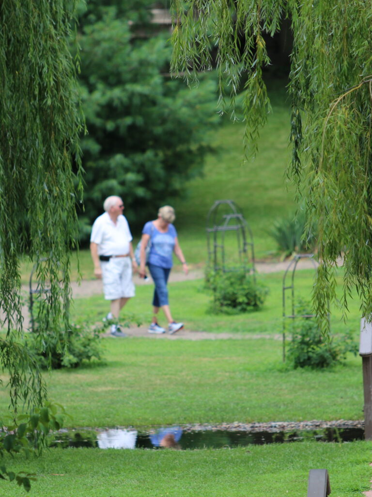 a couple walking down a path in a garden